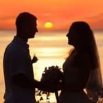 Shape of a bride and groom on the beach at sunrise time